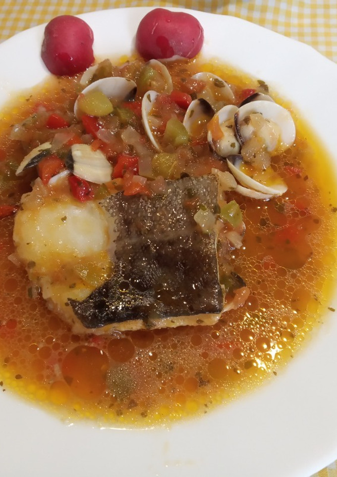Una foto de Lomos de Bacalao con tomate pimientos y almejas