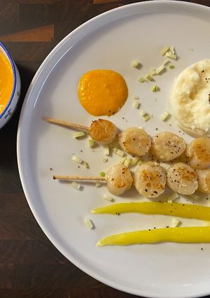 Une photo de Brochette de pétoncles et crème de poivrons