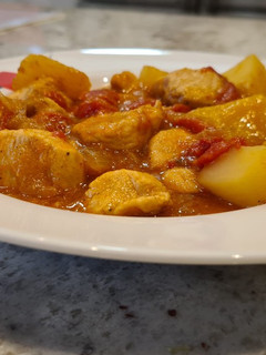Una foto de Dados de pollo en salsa de pimientos del piquillo con patatas
