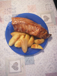 Una foto de Costillar al horno con salsa barbacoa y patatas