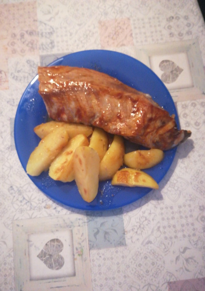 Una foto de Costillar al horno con salsa barbacoa y patatas