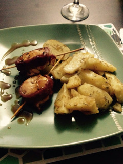 Una foto de Rollitos de pollo envuelto en tocino y salsa teriyaki con papas a la mantequilla, romero y merkén