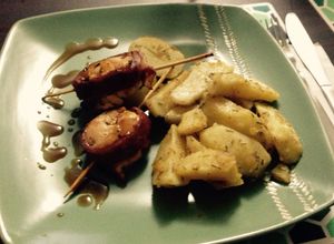 Una foto de Rollitos de pollo envuelto en tocino y salsa teriyaki con papas a la mantequilla, romero y merkén