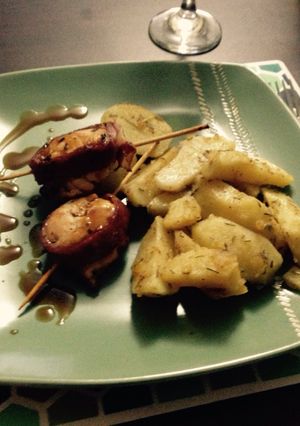Una foto de Rollitos de pollo envuelto en tocino y salsa teriyaki con papas a la mantequilla, romero y merkén
