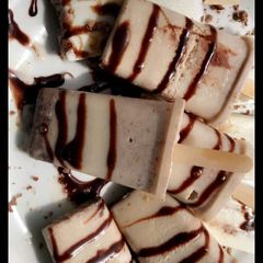 A picture of Homemade vanilla ice pop glazed with chocolate syrup.