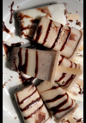 A picture of Homemade vanilla ice pop glazed with chocolate syrup.