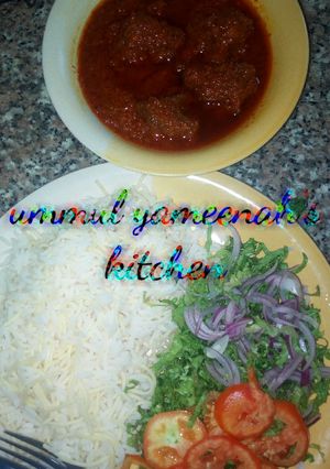 A picture of White rice and spaghetti with stew.