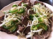 Una foto de carne frita encebollada