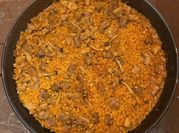 Una foto de paella de carne