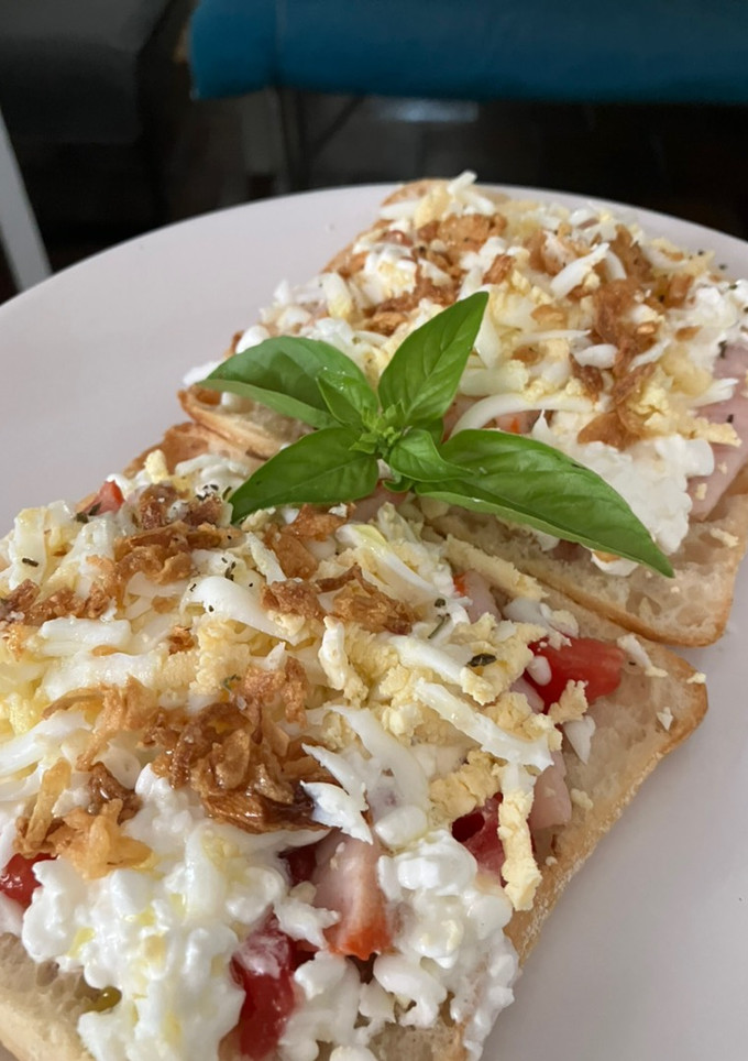 Una foto de Tostada con lomo adobado, queso cottage, tomate, huevo cocido y cebolla frita