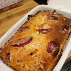 A picture of Veggie Toad in the Hole with red onion and mustard.