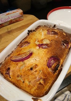 A picture of Veggie Toad in the Hole with red onion and mustard.