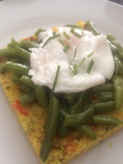 Una foto de Timbal de cuscus con hortalizas y huevo poche con aceite de trufa