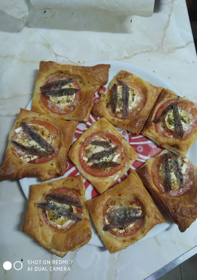 Una foto de Mini bocaditos de hojaldre con tomate, queso de cabra y anchoas