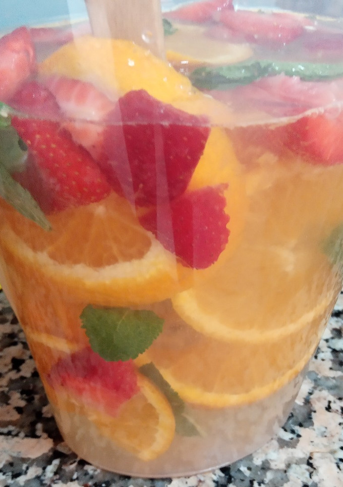 Una foto de Agua de naranja, fresas y hierbabuena