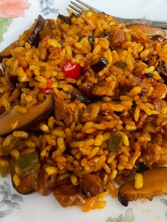 Una foto de Chicharrones de secreto ibérico con setas y arroz en paella