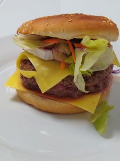 Una foto de Hamburguesa de ternera con rulo de cabra y cebolla caramelizada