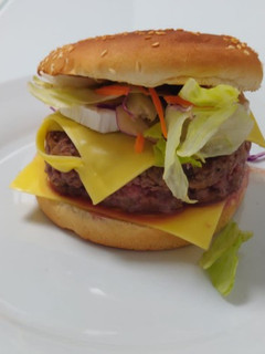 Una foto de Hamburguesa de ternera con rulo de cabra y cebolla caramelizada