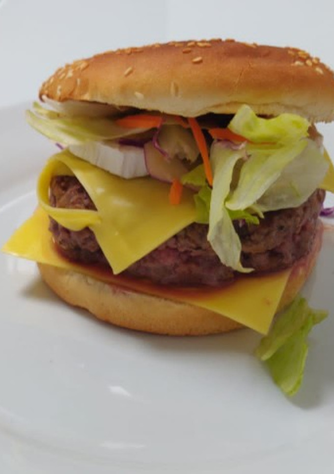 Una foto de Hamburguesa de ternera con rulo de cabra y cebolla caramelizada