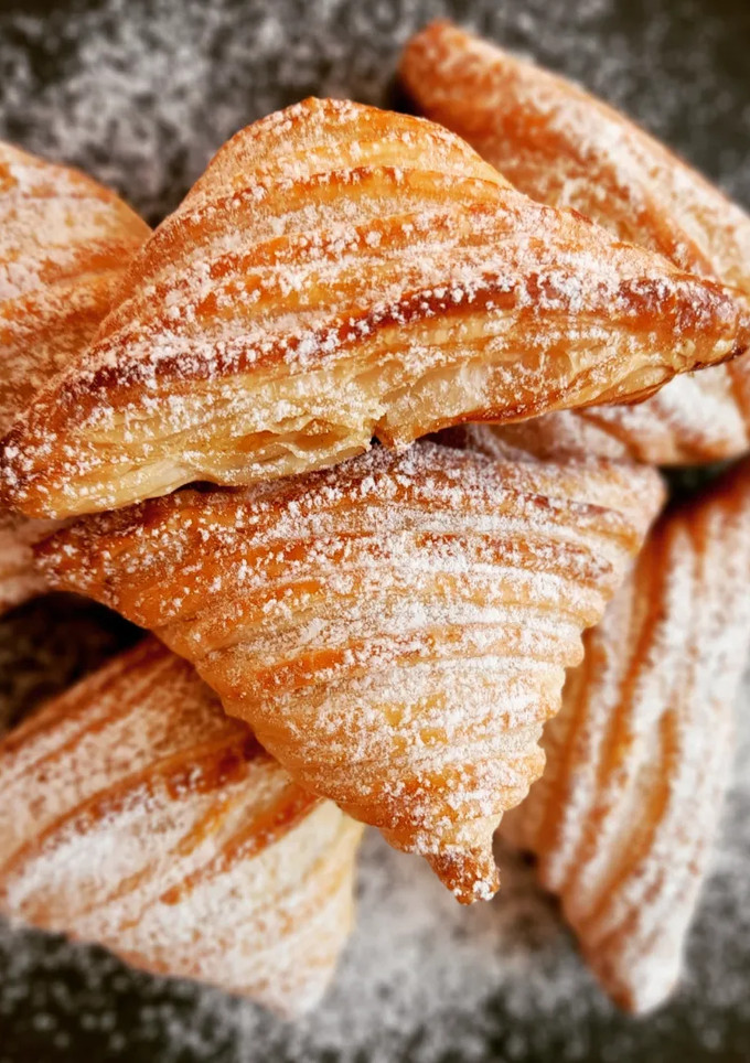 Una foto de Triángulos de hojaldre, crema y manzana