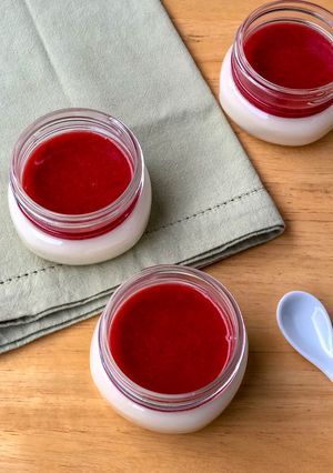 Una foto de Panna Cotta de miel con salsa de fresa