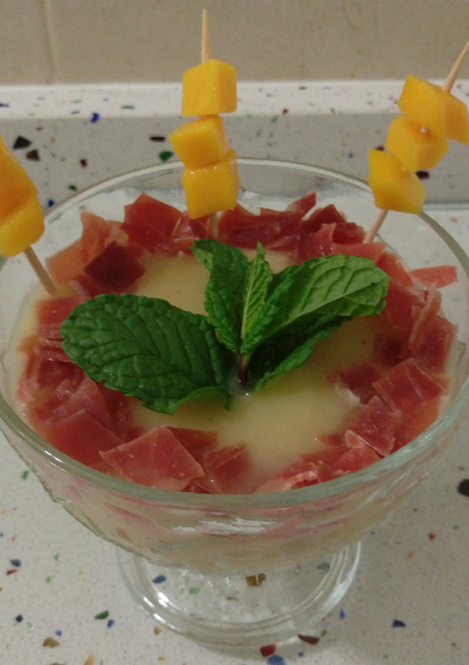 Una foto de Crema de espárragos y alcachofas con jamón y mango