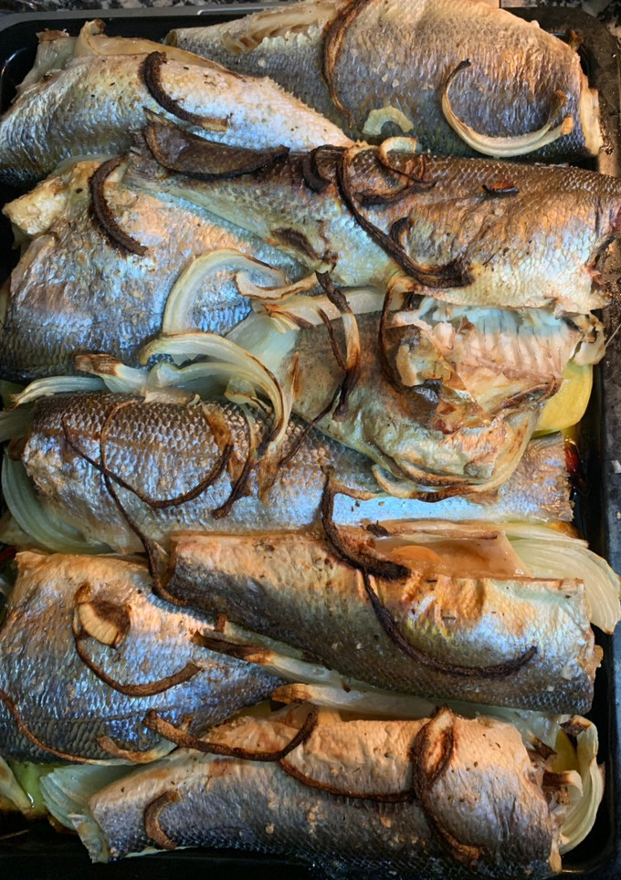 Una foto de Lubina al horno con cebolla y patatas