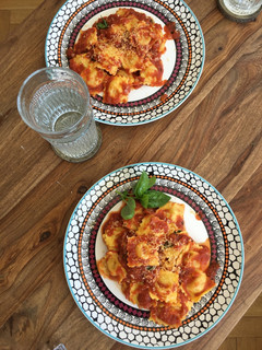 Una foto de Pasta rellena de queso con salsa de tomate frito casero y albahaca