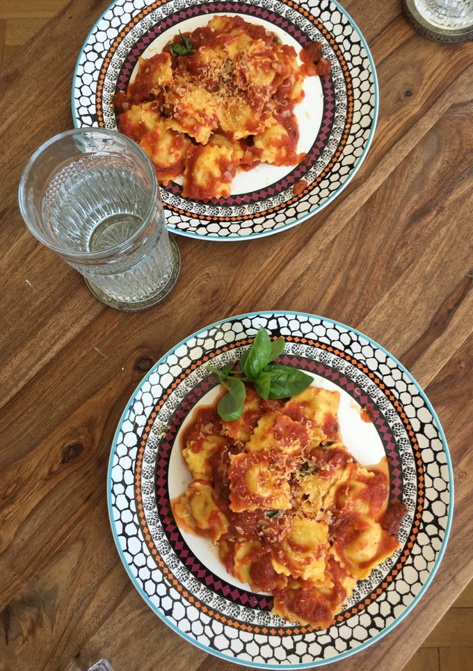 Una foto de Pasta rellena de queso con salsa de tomate frito casero y albahaca