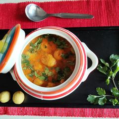 A picture of Dhania flavoured moong dal balls in red tomato curry.