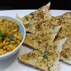 A picture of Garlic Bread Toast with corn chaat.