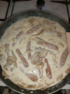 Una foto de Salchichas con champiñones y cebolla a la crema