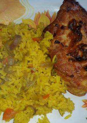 Una foto de Cerdo con hierbas frescas, especiado con arroz amarillo