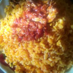 A picture of Palm oil rice and sauced fish.