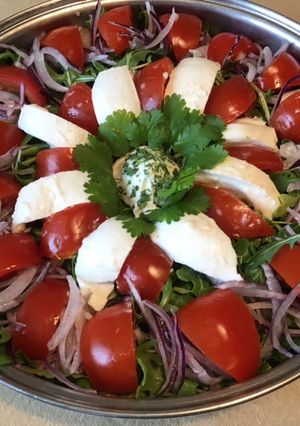 Une photo de Salade de roquette aux tomates divinina,oignon rouge et mozzarella di buffala