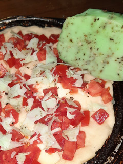 Una foto de Pizza bianca, queso al pesto y tomates frescos