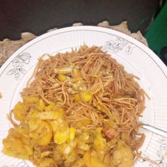 A picture of Brown spaghetti with fried potato sauce.