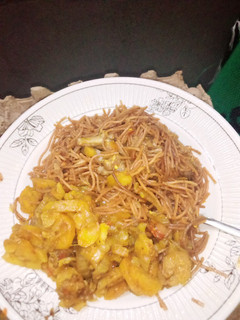 A picture of Brown spaghetti with fried potato sauce.