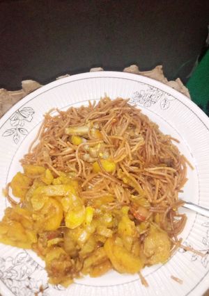 A picture of Brown spaghetti with fried potato sauce.