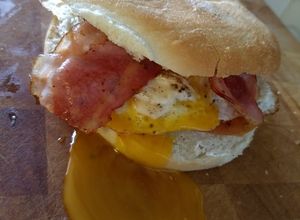 Una foto de Bagel con tocino, huevo y jitomate asado