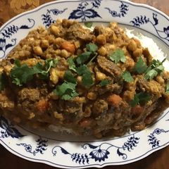 A picture of California Farm Goat Confit with Garbanzo Beans.