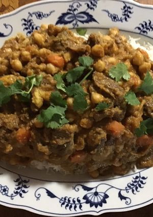 A picture of California Farm Goat Confit with Garbanzo Beans.