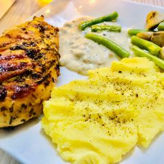 A picture of Chicken breast steak with sauce mashed potatoes and mushroom.
