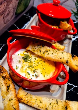 Une photo de Œufs cocotte au poulet et au cheddar