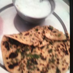A picture of Palak Paratha with curd.
