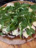 Pizza de hongos Portobellos y rúcula sobre masa integral