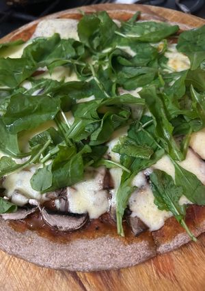 Una foto de Pizza de hongos Portobellos y rúcula sobre masa integral