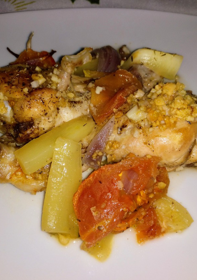 Una foto de Muslitos con verduras al horno