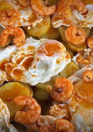 Una foto de Huevos rotos con langostinos