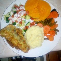 A picture of Vegetable plate with fried fish.